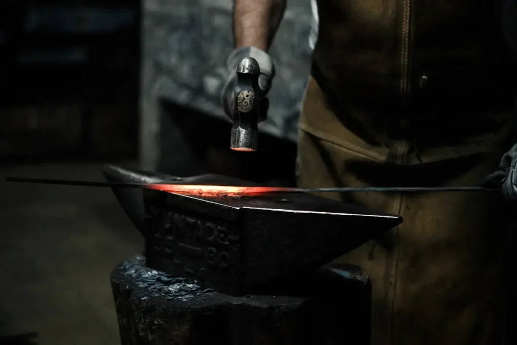 Forja de metal al rojo sobre yunque